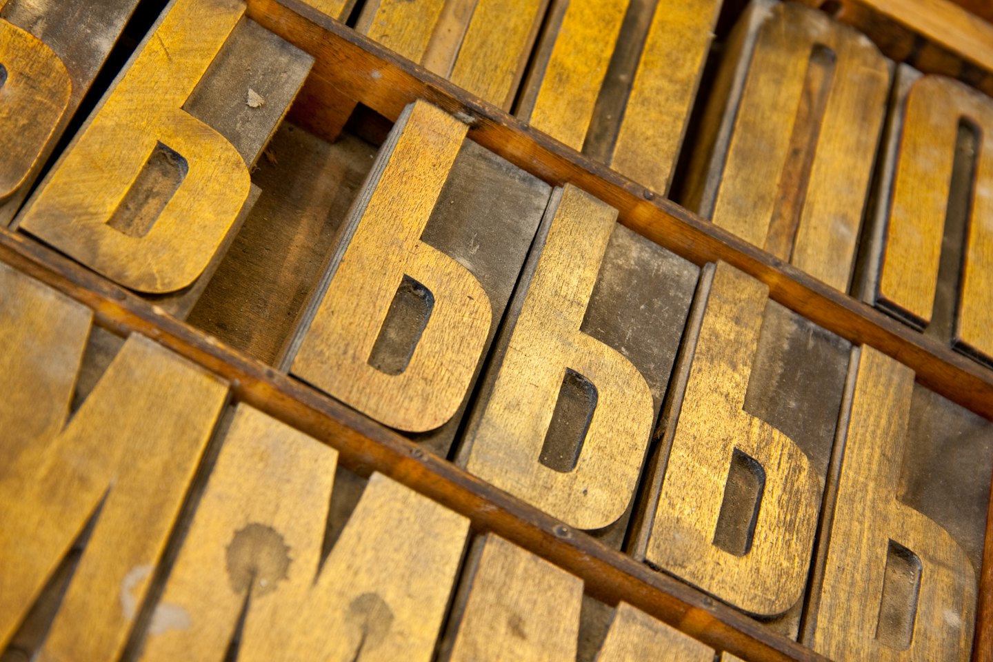 Drewniane klocki typograficzne w drewnianej tacy.