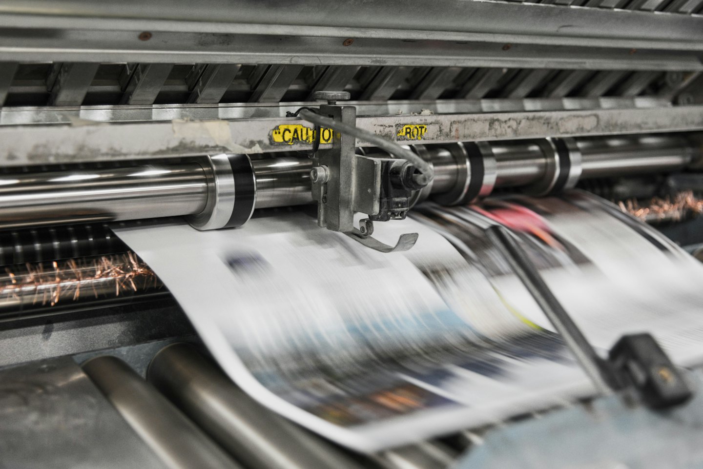 Prasa drukarska podająca papier przez metalowe wałki.